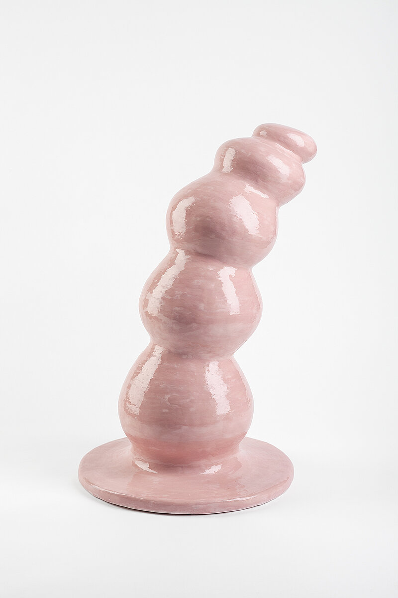 Ein rosafarbenes Keramikobjekt auf einem weißen Hintergrund.