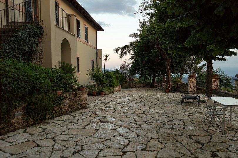 Eine mediterrane Terrasse mit einem Haus dahinter. 