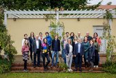 Das Team der Kulturstiftung Sachsen steht im Garten vor den Bürohäusern 