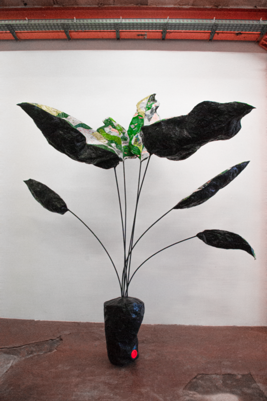Foto einer übermannshohen, ausgeblasenen Zimmerpflanze aus Kunststoff.