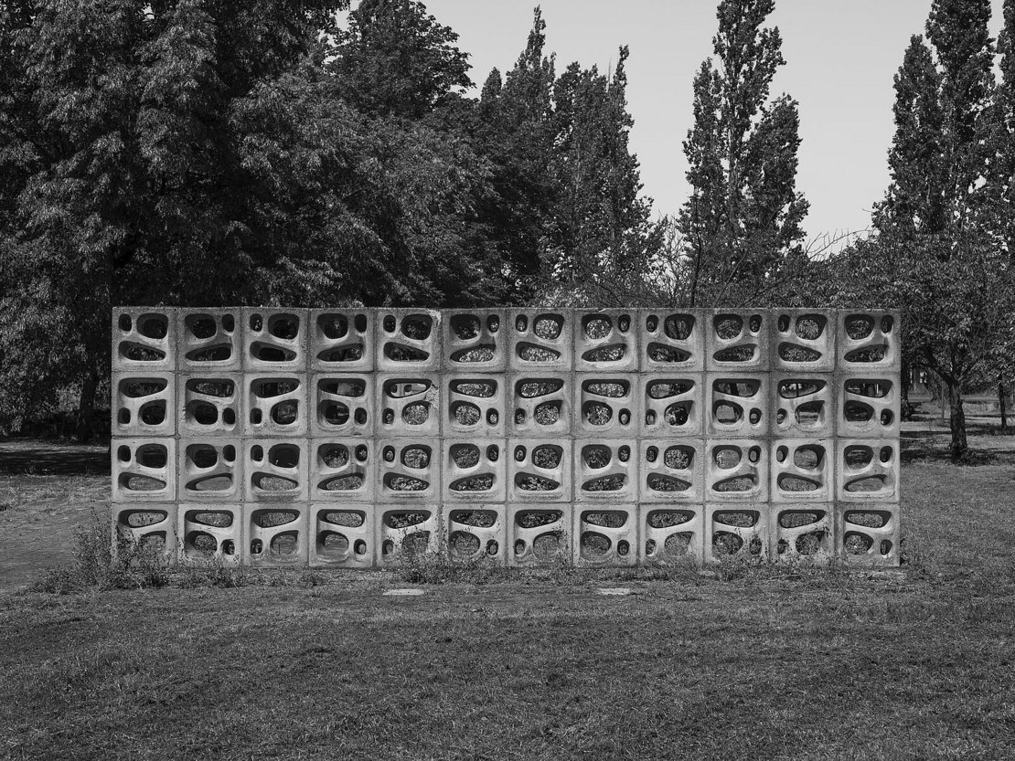 Ein Schwarz-Weiß-Foto von einer Betonmauer in einem Park.