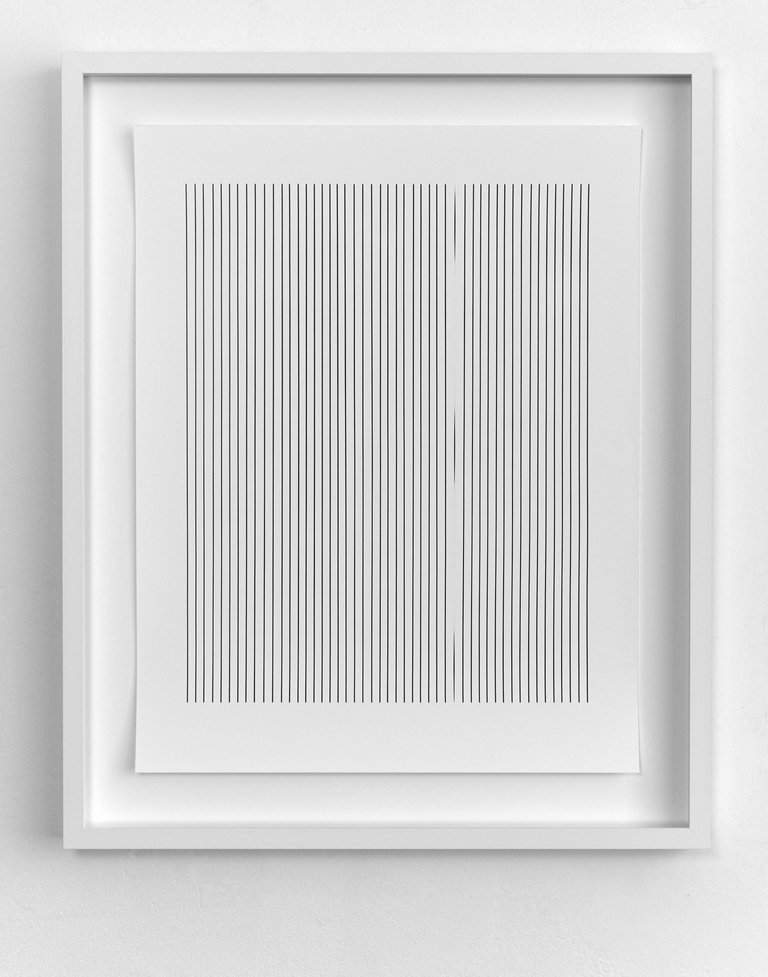 Ein weißes Photogramm mit schwarzen Längsstreifen hängt in einem weißen Rahmen an einer Wand. 