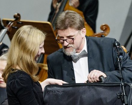 Annemarie Hoffman wird auf einer Orchesterbühne eine Violine des Instrumentenbauers Nicolas Augustin Chappuy überreicht.