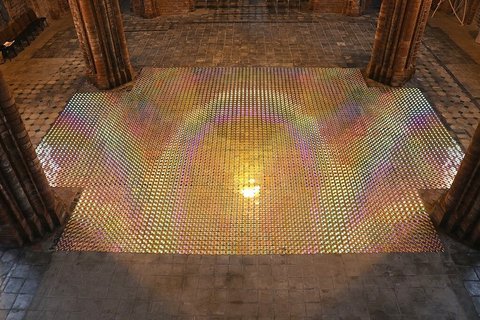 Eine Glaskonstellation auf steinernem Boden erstrahlt in Regenbogenfarben.